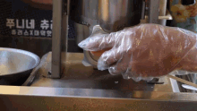 a person wearing plastic gloves is using a machine that has chinese writing on it