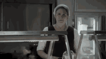 a woman is standing at a counter in a kitchen wearing a white headband .