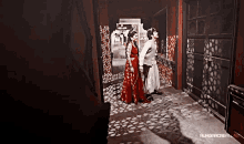 a woman in a red dress is standing next to a man