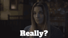 a woman in a dark room with the words " really " behind her