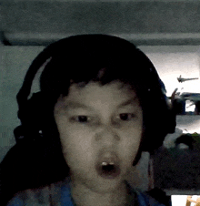 a young boy wearing headphones is making a surprised face