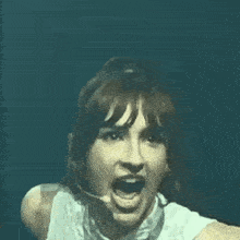 a woman is singing into a microphone while wearing a headset .