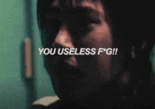 a close up of a person 's face with the words `` you useless f * g ! '' written above it .
