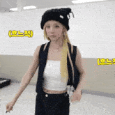 a woman wearing a black beanie and a white crop top