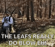 a man is sitting in the grass with a parachute in the woods .