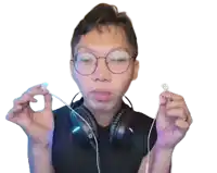 a man wearing glasses and headphones is holding a pair of ear buds