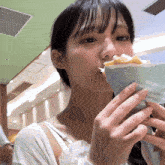 a woman is eating a sandwich with a paper that says ee eeonb