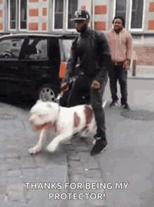 a man is walking a dog on a leash on the sidewalk .