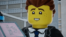 a lego man in a tuxedo is holding a pink cake that says happy birthday
