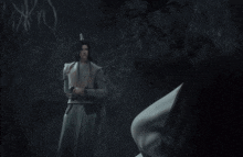 a man in a white robe stands next to another man