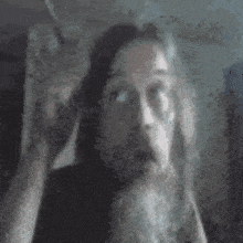 a man with a beard and glasses is making a funny face in a blurry photo .