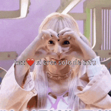 a woman is making a heart shape with her hands and the words haz si eres solo de tofu