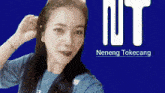 a woman taking a selfie in front of a blue background that says " nt "