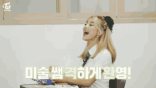 a girl in a school uniform is sitting at a desk with korean writing on the wall