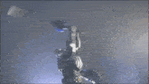 a man in a knight 's armor is holding a sword in a dark room