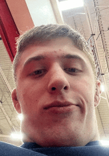 a close up of a man 's face with a blue sweater on