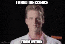 a man is standing in front of a picture with the words to find the essence from within on it .