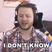 a man wearing headphones and a plaid shirt says i don 't know