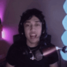 a man wearing headphones is sitting in front of a microphone .