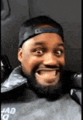 a man with a beard is wearing a hat and a jacket that says squad on it