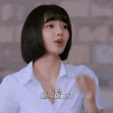 a woman with short hair is wearing a white shirt and a necklace .