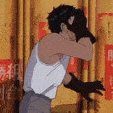a man in a white tank top and black gloves covering his face