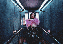 a woman in a purple top is standing in a hallway