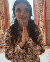 a woman in a leopard print shirt is praying