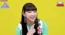 a girl in a green shirt is smiling and talking in a video .