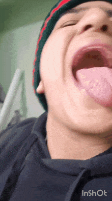 a close up of a person 's mouth with their tongue sticking out and the words inshot below it