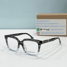 a pair of burberry glasses sits next to a cardboard box