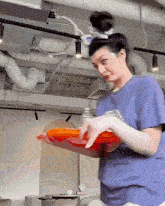 a woman in a blue shirt is holding a red tray
