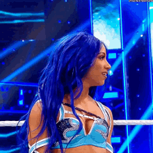 a woman with blue hair is standing in a ring .