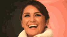 a woman is laughing with her mouth open and wearing a white turtleneck sweater .