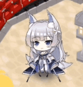 a little girl with white hair and blue eyes is sitting on the floor .