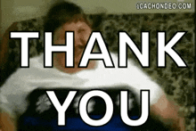 a man is laying on a couch with the words `` thank you '' above him .