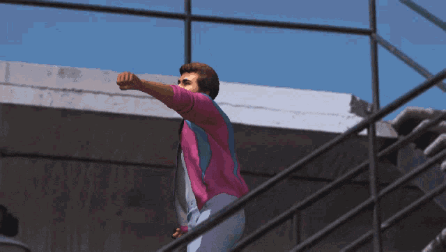 a man wearing a pink and blue jacket is standing on a set of stairs