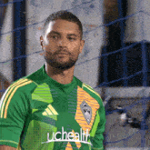 a man in a green and yellow uchealth jersey