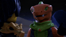 a lego character with a green scarf around his neck looks at another lego character