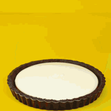 a pie with a black crust and white frosting is being scooped out with a gold spoon