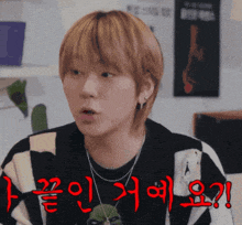 a young man with korean writing on his face looks surprised