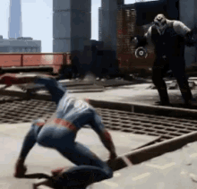 a man in a spiderman costume is crawling on the ground while a man in a mask stands behind him