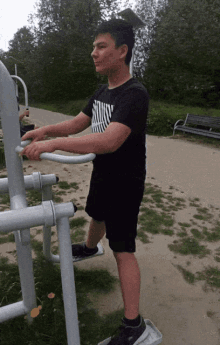 a man wearing a black shirt that says nike on it is using a machine