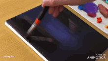 a person is painting on a piece of paper with the words made in animatica on the bottom right