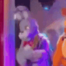 a stuffed bunny rabbit is standing in front of a stage in a room .