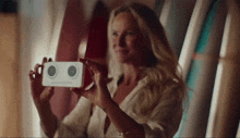 a woman is taking a picture of herself with a cell phone