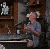 a man is sitting at a table with a microphone and the word yes is above him