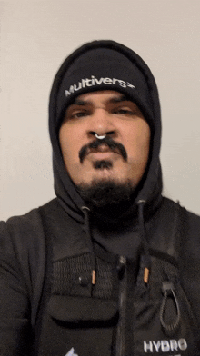 a man wearing a hooded jacket and a beanie that says multivers