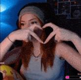 a woman making a heart with her hands in front of her face