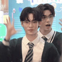 a man wearing glasses stands next to another man in front of a sign that says air